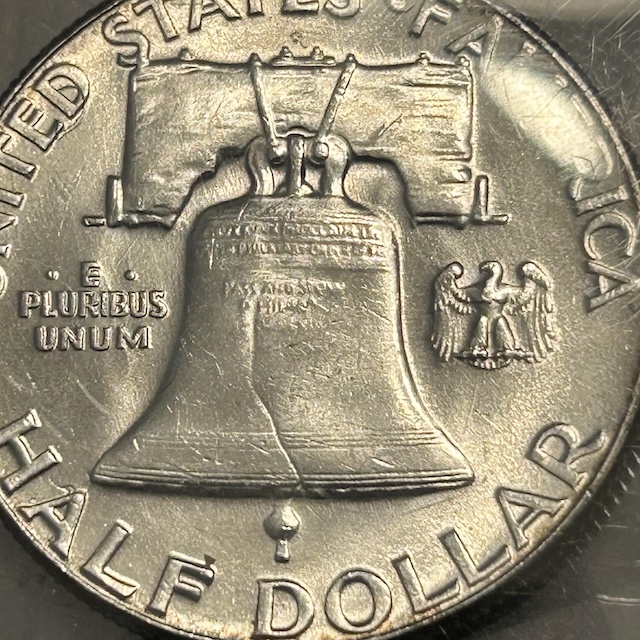 Close-up comparison of Full Bell Lines (FBL) versus weak bell lines on the reverse of a 1954 Franklin Half Dollar, showing horizontal lines at the base of the Liberty Bell